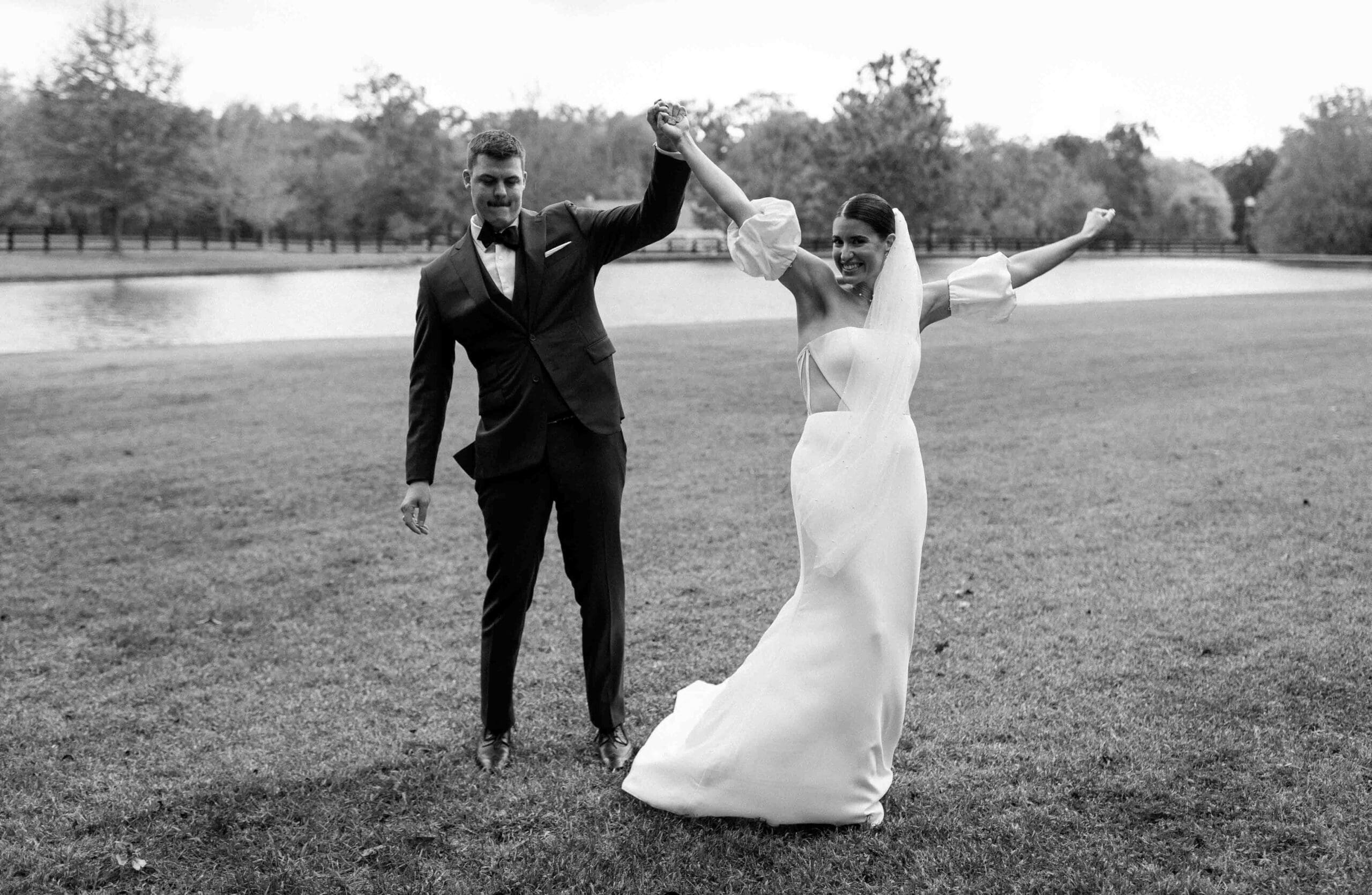 bride and groom celebrating together by the pond on morning glory farms located in charlotte north carolina