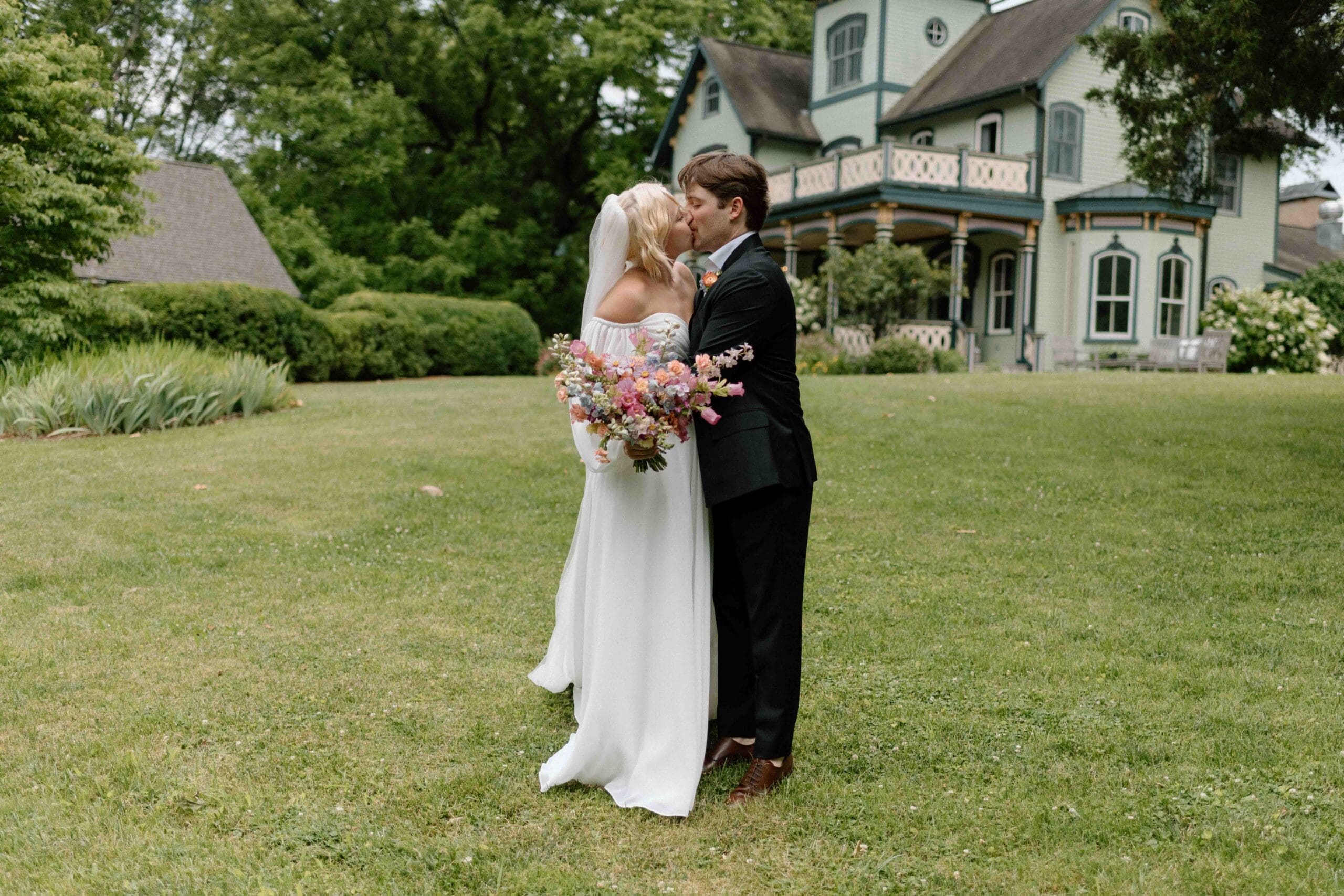 Couple embracing in front of the Magnolia House wedding venue during their time together after their ceremony